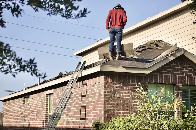 Professional roofer working on a residential roof in Lowry Field